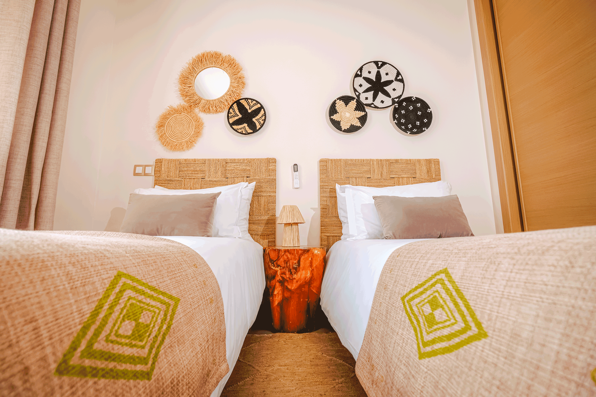 Chambre avec lits jumeaux et décoration murale tissée